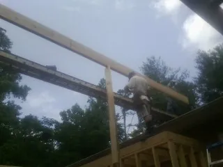 Carpenter setting a ridge beam over a new addition frame — Ice Dam Removal by Roofing Brothers in Neversink