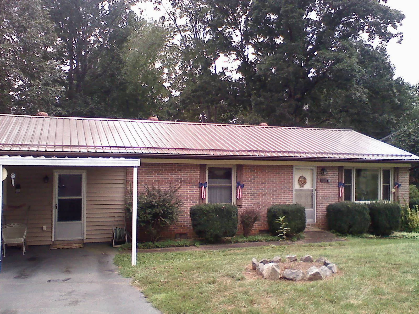 Bronze metal roof and carport on a brick ranch home — Roof Repair work by our crew in Neversink